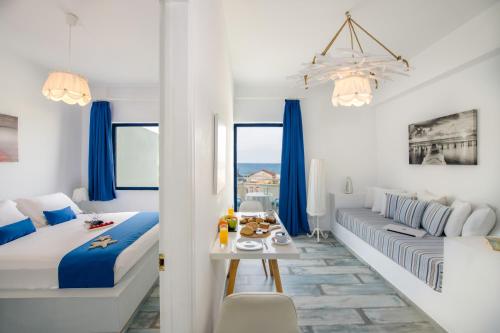 een witte slaapkamer met een bank en een tafel in een kamer bij Seagull Hotel and Apartments in Agia Marina Nea Kydonias