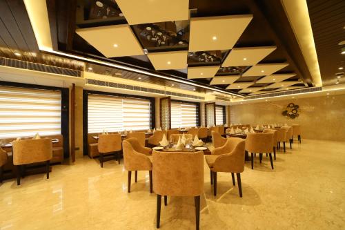 a restaurant with tables and chairs in a room at Hotel DVIJ INN in Jaipur