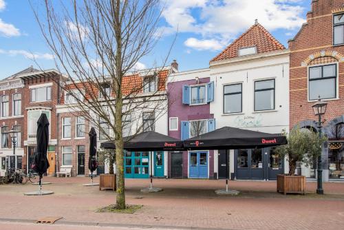 a building with a black umbrella on a city street at Turfhuys aan het Spaarne in Haarlem
