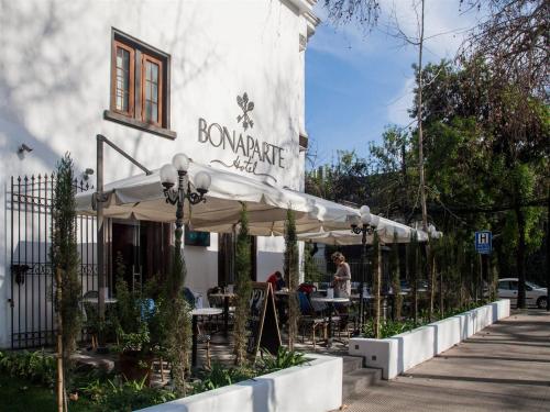 a restaurant with tables and umbrellas in front of a building at Park Plaza Bonaparte Boutique in Santiago