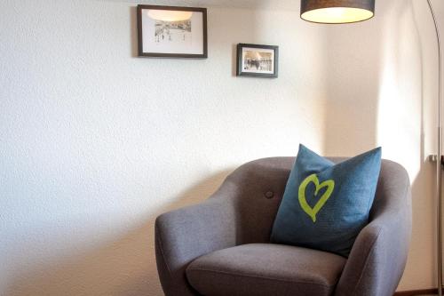 a chair with a blue pillow with a yellow heart on it at Haus am Berg - Pension direkt am Skihang in Kurort Oberwiesenthal
