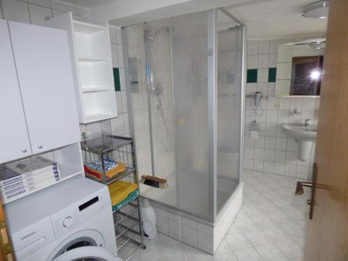 a bathroom with a shower and a washing machine at Werner's Gästewohnung in Kraftsdorf