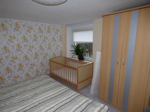 a bedroom with a crib and a plant on the wall at Werner's Gästewohnung in Kraftsdorf