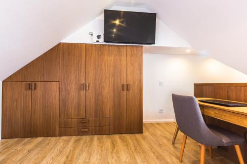 ein Loft-Büro mit einem Schreibtisch und einem TV an der Wand in der Unterkunft Apartman Maria - Krila Zlatibora in Zlatibor