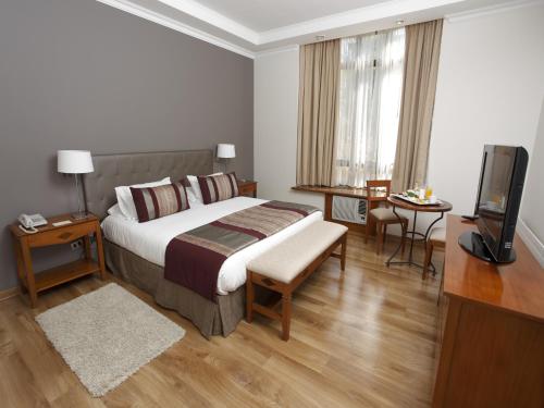 a hotel room with a bed and a flat screen tv at Park Plaza Bonaparte Boutique in Santiago