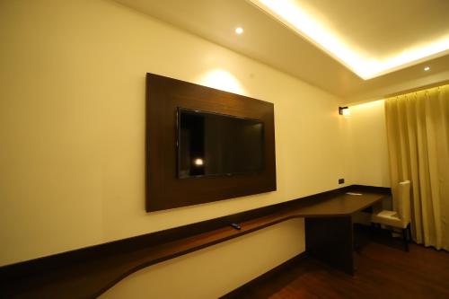 a room with a flat screen tv on the wall at Hotel DVIJ INN in Jaipur