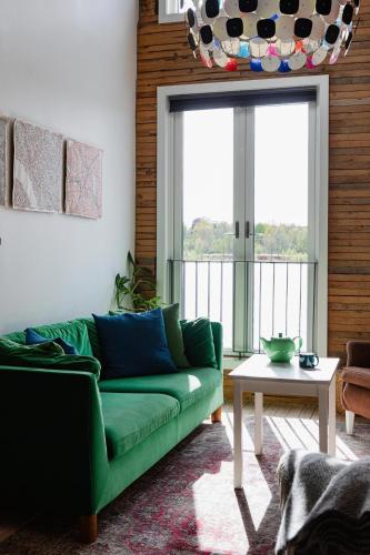 a living room with a green couch and a table at Upperud 9:9 in Åsensbruk