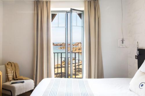 una camera con letto e vista sull'oceano di Castel Beau Site a Perros-Guirec