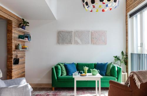 Upperud 9:9 في Åsensbruk: أريكة خضراء في غرفة المعيشة مع طاولة