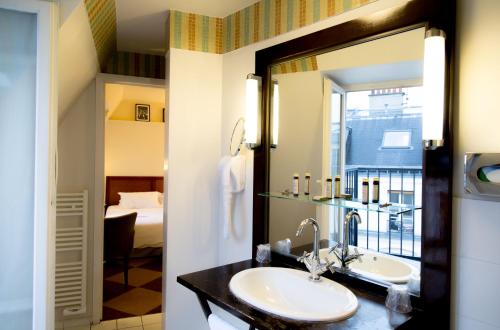 y baño con lavabo y espejo. en Hôtel Quartier Latin, en París