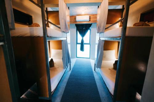 a room with four bunk beds with a window at Frendz Hostel El Nido in El Nido