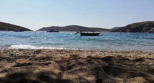 a beach with two boats in the water at Costareli in Fourni Ikarias