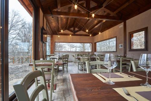Relais Villa Miraglia في Cesarò: غرفة طعام مع طاولات وكراسي ونوافذ