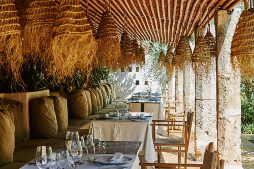 an outdoor dining area with tables, chairs and umbrellas at Faustino Gran Relais & Chateaux in Ciutadella