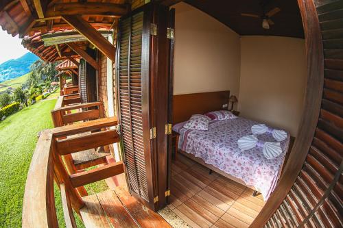 a bedroom with a bed on a wooden deck at Pousada Pedra da Mina in Passa Quatro
