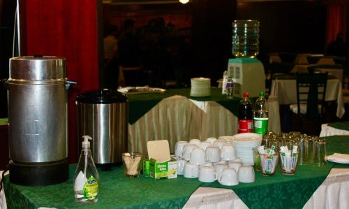a table with a green table cloth with bottles and cups at Hotel 6 De Diciembre in Quito