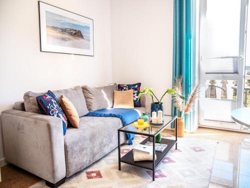 a living room with a couch and a table at Apartament Sunset Boulevard z tarasem dla 4 gości in Gdynia