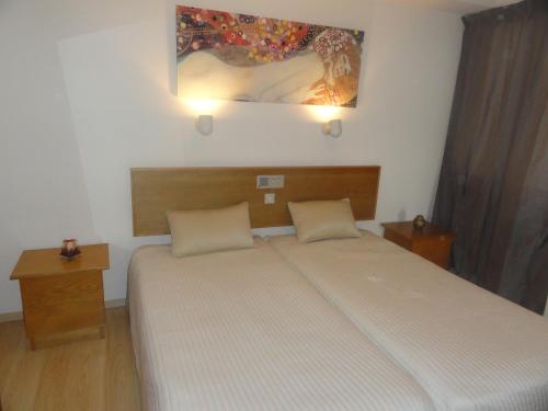um quarto com uma cama e um quadro na parede em Sunorama Beach Apartment em Lárnaca