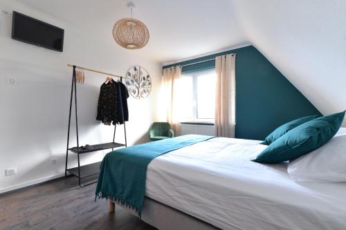 - une chambre avec un lit doté d'une tête de lit bleue et d'une fenêtre dans l'établissement Entre Ried et Rhin, à Marckolsheim