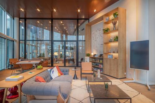 a living room with a couch and a flat screen tv at INNSiDE by Meliá Amsterdam in Amsterdam