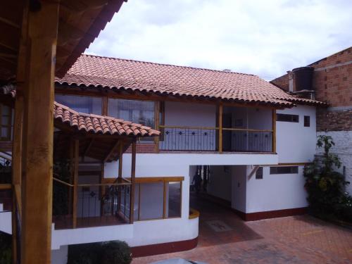 a house with a balcony with a tiled roof at Hotel Cacique Real in Zipaquirá
