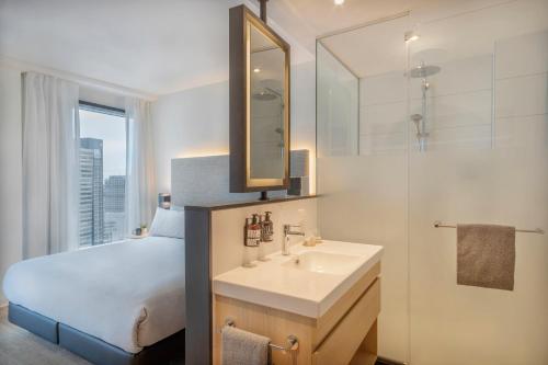 a hotel room with a large mirror above the sink at INNSiDE by Meliá Amsterdam in Amsterdam
