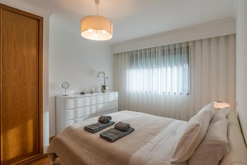 una camera da letto con un letto con due asciugamani sopra di Porto Gaia RR Apartment by MP a Vila Nova de Gaia
