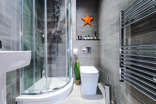 a bathroom with a shower and a toilet and a sink at Exceptional Rated Apartment Sheffield in Sheffield