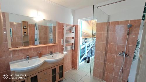 a bathroom with two sinks and a glass shower at Villa les Palmiers - Aux Portes d'Alès in Saint Julien Les Rosiers