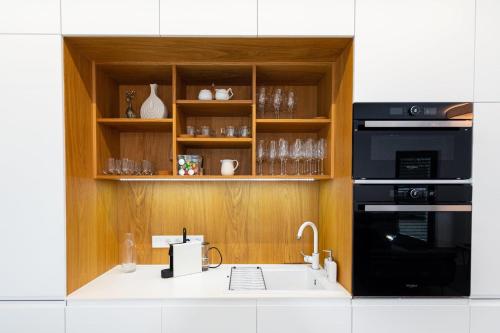 eine Küche mit einer Spüle und einer Mikrowelle in der Unterkunft Bony Resort in Szarvas