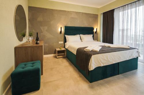 a bedroom with a large bed and a chair at Lotus Exclusive in Mamaia Sat/Năvodari