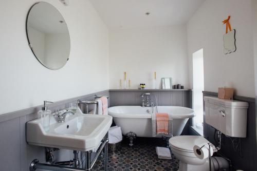 a bathroom with a sink and a tub and a toilet at Tom Blake House in Kells