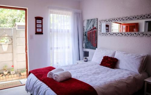 a bedroom with a large white bed with a window at La Grâce, Durbanville in Cape Town