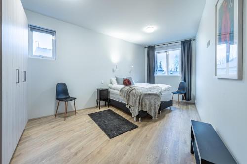 - une chambre avec un lit et deux chaises dans l'établissement Nortia Apartments, à Fludir