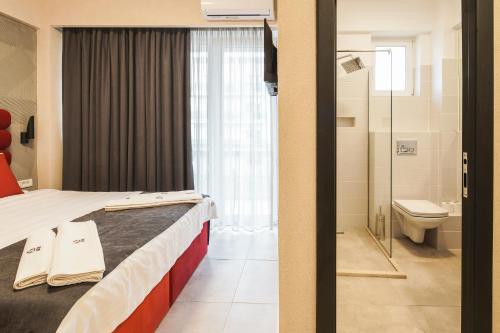 a hotel room with a bed and a bathroom at Lotus Exclusive in Mamaia Sat/Năvodari