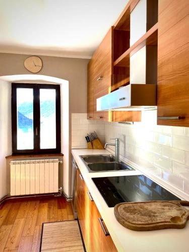 a kitchen with wooden cabinets and a sink and a window at Casa Paradiso in Vione