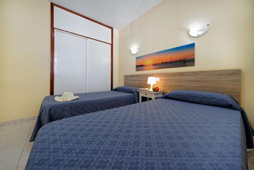 מיטה או מיטות בחדר ב-Apartamentos Strelitzias