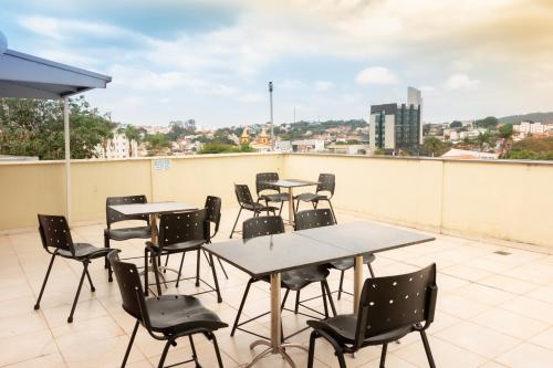 a group of tables and chairs on a roof at Contagem Centro Hotel in Contagem
