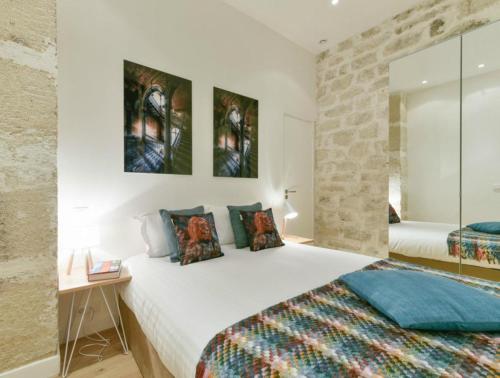 パリにあるBulleの白い大型ベッドとレンガの壁が備わるベッドルーム1室が備わります。