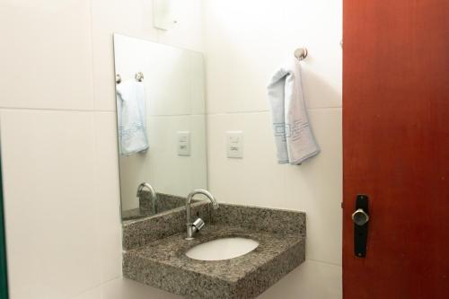 a bathroom with a sink and a mirror at Contagem Centro Hotel in Contagem