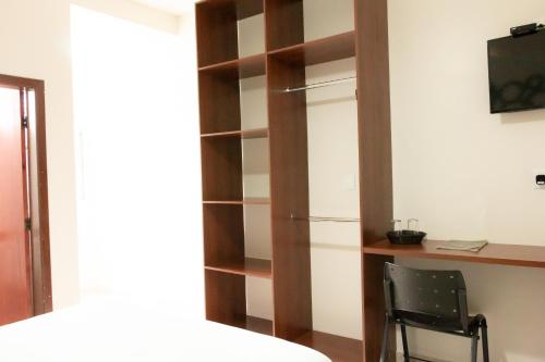 a closet with a desk and a chair in a room at Contagem Centro Hotel in Contagem