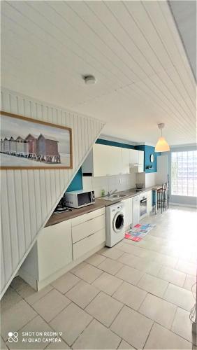a kitchen with white cabinets and a staircase at Villa les Palmiers - Aux Portes d'Alès in Saint Julien Les Rosiers