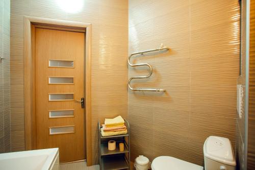 a bathroom with a toilet and a glass shower door at back in USSR in Kherson