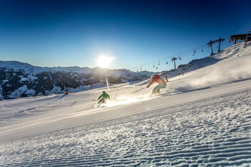 two people skiing down a snow covered ski slope at Apartment Nester in Stumm