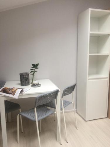 a white table and chairs with a plant on it at Hostelik Przy Przystanku in Gryfino