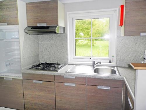 una cocina con fregadero y ventana en Holiday Home Den Oever by Interhome, en Den Oever