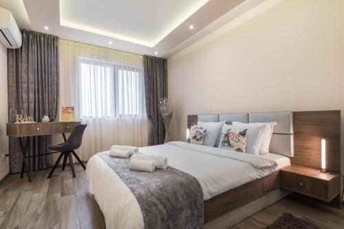 1 dormitorio con 1 cama grande y escritorio en Apartments Cats, en Varna