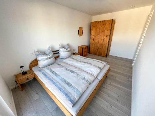 een slaapkamer met een groot bed met witte lakens en kussens bij Ferienwohnung König Ludwig XIV in Saarlouis