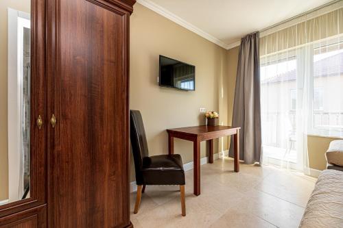 a bedroom with a desk and a chair and a table at Sakura_INN Palanga in Palanga