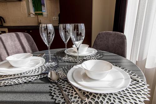 a table with plates and wine glasses on it at Sakura_INN Palanga in Palanga